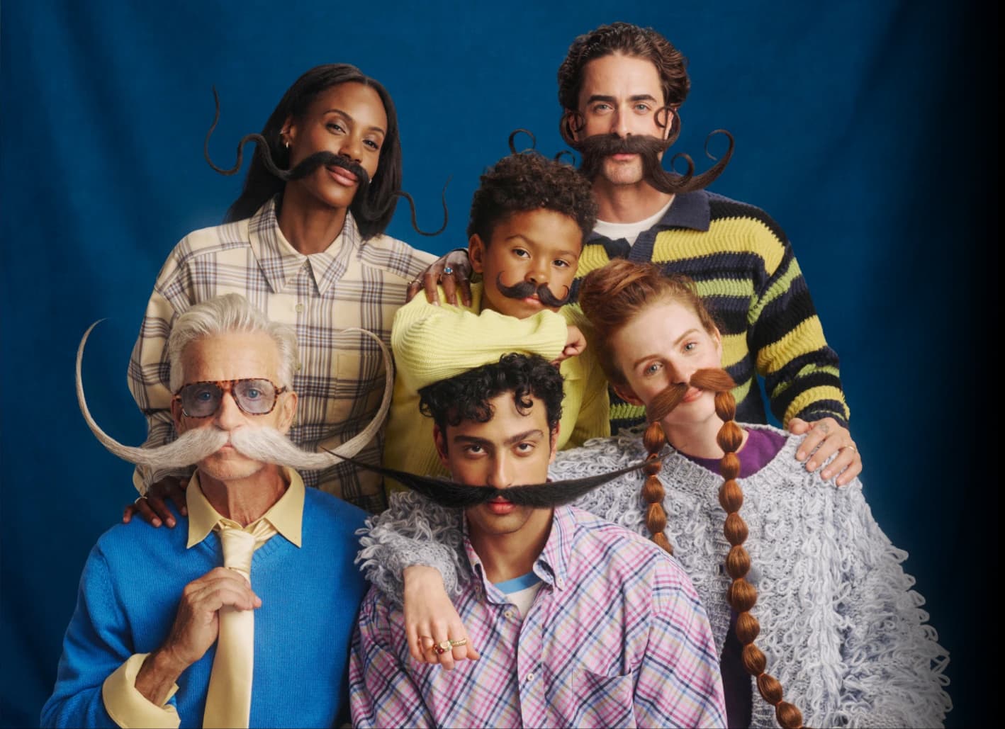 Six Stash members with dramatic moustaches posed together against a blue backdrop